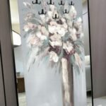 لوحة فنية مزينة بمرايا وعلاقات، بألوان هادئة وتصميم زهور أنيق، إطار أسود أنيق.