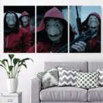 ثلاث لوحات قماشية تحمل صور شخصيات من مسلسل لا كاسا دي بابل، بألوان حمراء وبيضاء، مع تفاصيل دقيقة.
