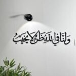 منحوتة اكريليك باللون الأسود تحمل عبارة "ولنا في الله ظن لا يخيب"، مزودة بإضاءة موجهة.