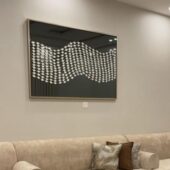مرآة مؤطرة بتصميم زخرفي عصري من الجبس، بلون رمادي داكن، تعكس الأناقة في ديكور المنزل.