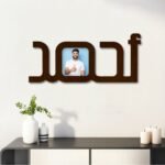 لوحة خشبية مودرن بلون بني مع إطار للصور بشكل اسم أحمد، تضيف لمسة أنيقة لأي ديكور.