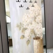 لوحة فنية كبيرة بتصميم زهور بيضاء مع مرايا وإكسسوارات لتعليق الأغراض، إطار أسود أنيق.