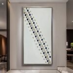 لوحة جبس بيضاء بتصميم مميز مع زخارف زرقاء وذهبية، إطار معدني أنيق.