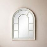 مرآة جدارية بتصميم قوس مميز، إطار أبيض من الخشب، تضيف لمسة عصرية لأي مساحة.