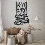 لوحة أكريلك سوداء بنقشة فنية تحمل عبارة "إن الله سميع بصير"، تضفي لمسة عصرية على الديكور الداخلي.