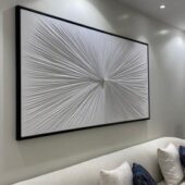 لوحة جبس بيضاء بتصميم ثلاثي الأبعاد، مؤطرة بإطار أسود، تبرز أشكالاً فنية متداخلة.