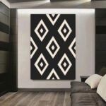 لوحة قماشية بتصميم تجريدي بالألوان الأسود والأبيض مع نمط ماسي مميز.