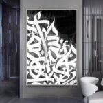 لوحة قماشية بتصميم خط عربي باللونين الأبيض والأسود، مع برواز مجوف أنيق.