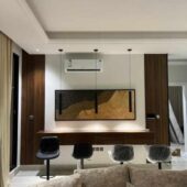 لوحة جبسية بألوان دافئة تتضمن تصميمًا هندسيًا معلقًا على جدار داخلي عصري.