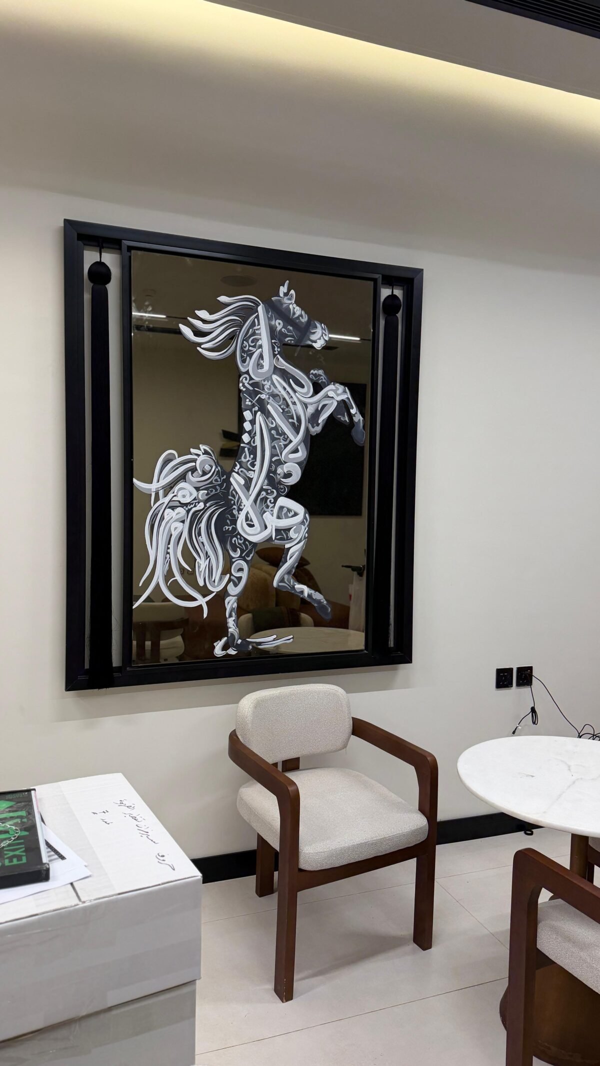لوحة فنية مرسومة على مراية، تظهر خيلًا بتصميم أنيق باللونين الأبيض والأسود، بإطار أسود عصري.