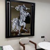 لوحة فنية مرسومة على مراية، تظهر خيلًا بتصميم أنيق باللونين الأبيض والأسود، بإطار أسود عصري.
