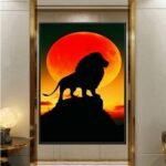 لوحة قماشية بتصميم مودرن، تحتوي على صورة أسد silhouetted أمام شمس غاربة بلون برتقالي.