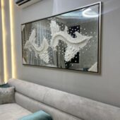 مرآة عتيقة بتصميم جبسيات مبتكرة، إطار فضي، تعكس زخارف فنية جميلة، مناسبة لديكور عصري.
