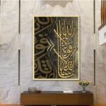 لوحة قماشية بتصميم إسلامي باللونين الأسود والذهبي مع برواز مجوف، تعكس فن الخط العربي.