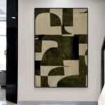 لوحة قماشية بتصميم هندسي بألوان داكنة، مع برواز مجوف أنيق.