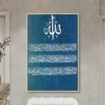 لوحة قماشية بتصميم إسلامي بلون أزرق مع برواز مجوف، تحمل آيات مكتوبة بخط عربي أنيق.